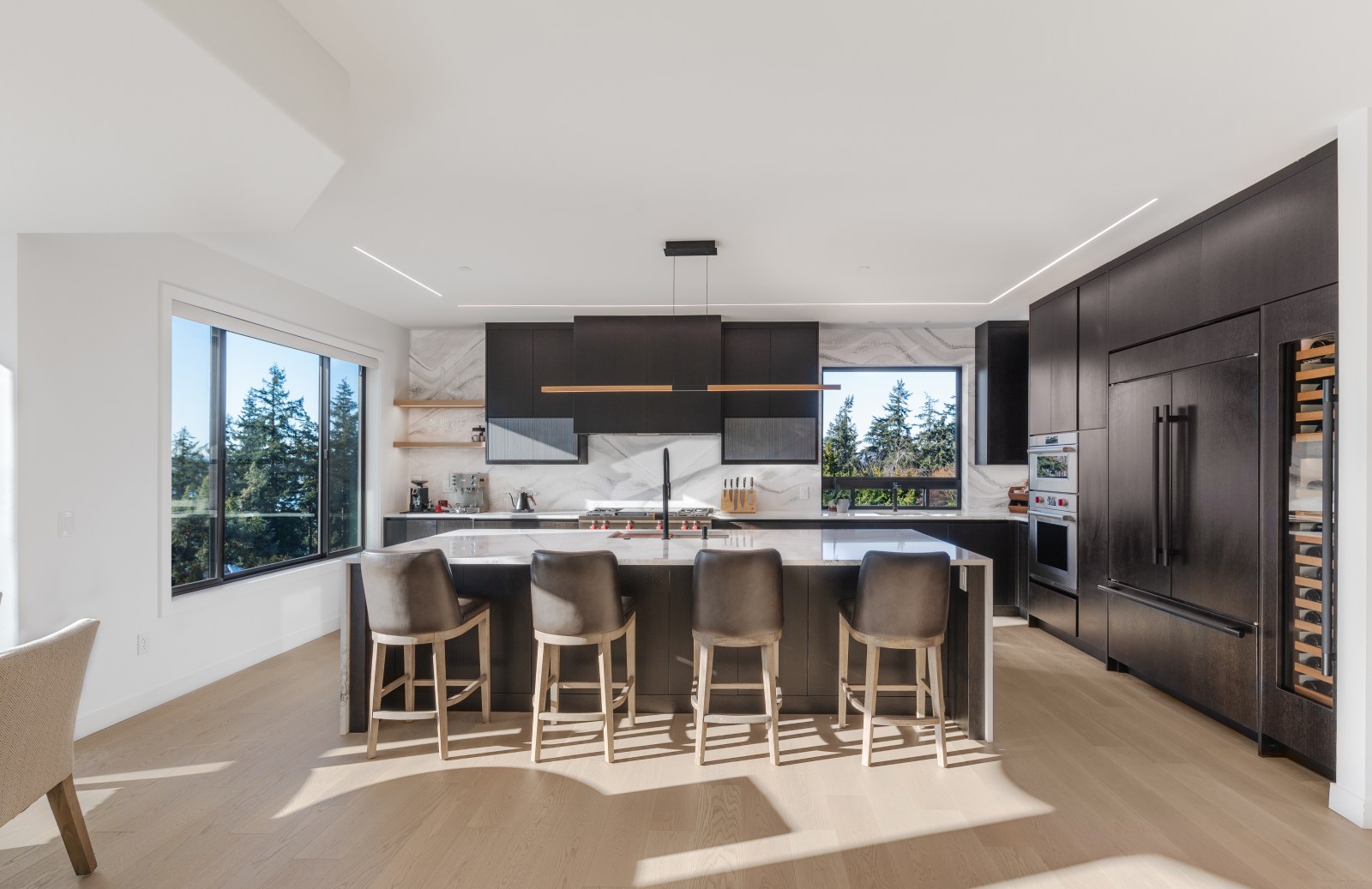 Dark contemporary slab custom kitchen cabinets with integrated refrigeration, wine storage and a waterfall island