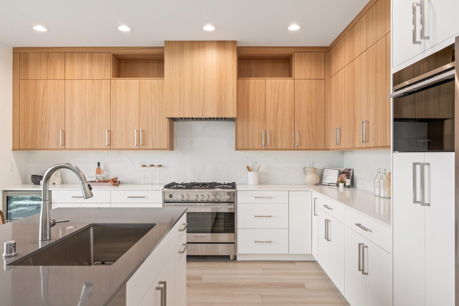 Two-tone custom kitchen with natural wood slab wall cabinets, white base cabinets and integrated appliances