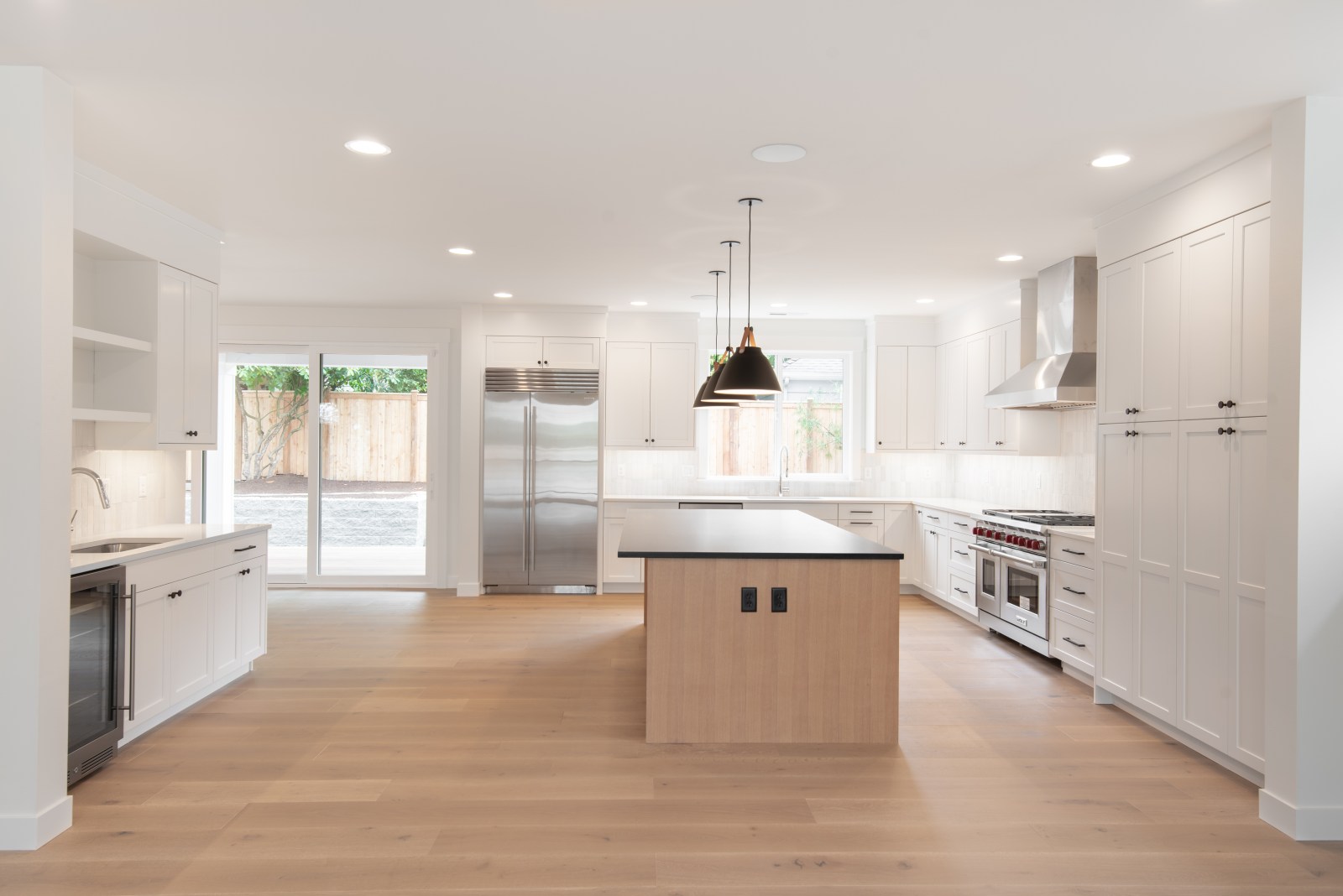 Classic white shaker custom kitchen cabinets with full-height pantry storage and a natural wood island