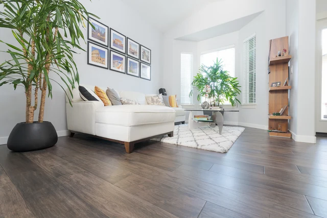 Gray living room flooring surrounding white seating and a pale area rug
