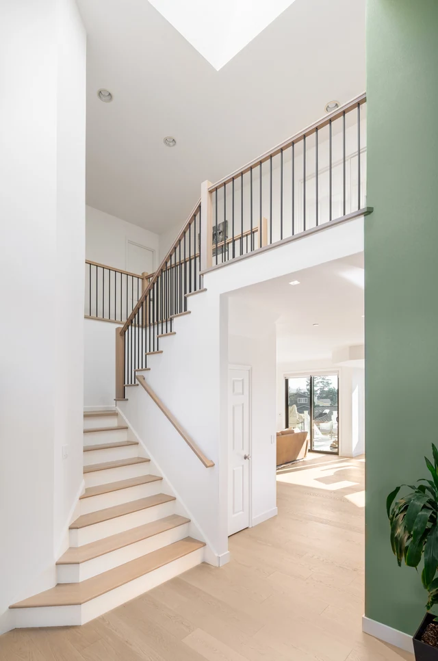 Klee entry staircase with light wood treads, white risers and slim black balusters