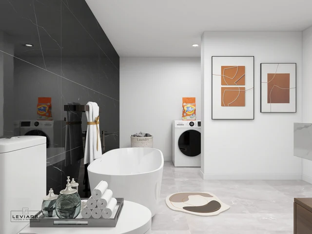 Freestanding white tub beside a dark tiled wall and recessed laundry area