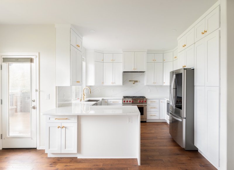 Custom white chef kitchen with professional appliances and tailored cabinetry, view 6 of 17