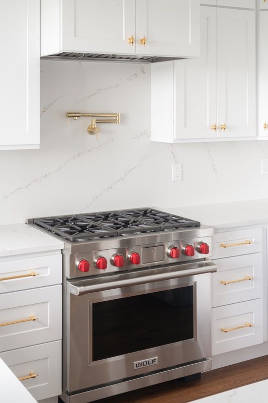 Custom white chef kitchen with professional appliances and tailored cabinetry, view 9 of 17