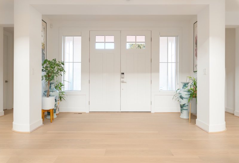Whole-home remodel with light oak flooring, kitchen and connected living spaces, view 1 of 9
