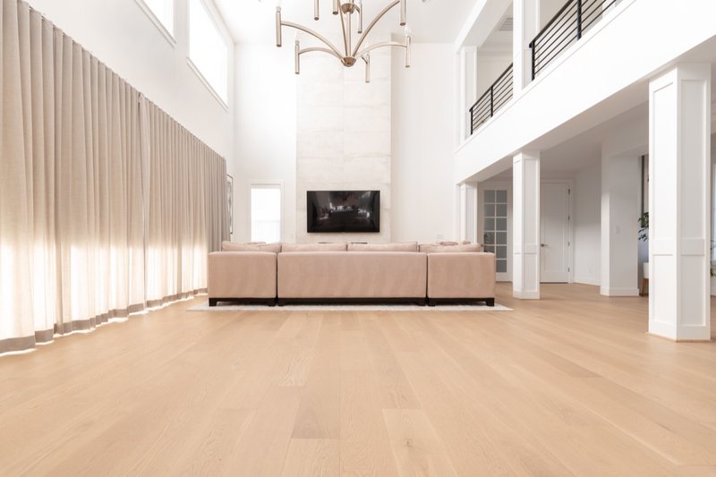 Whole-home remodel with light oak flooring, kitchen and connected living spaces, view 3 of 9