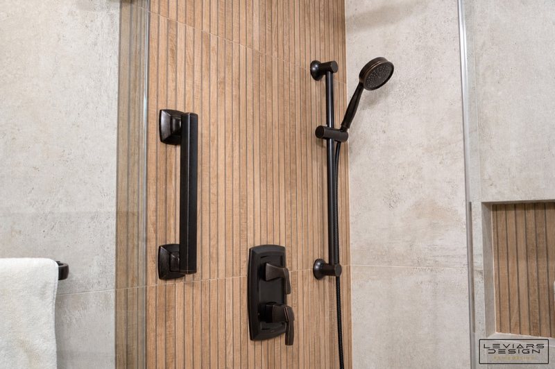 Warm modern bathroom with wood-look tile and black fixtures, view 5 of 8