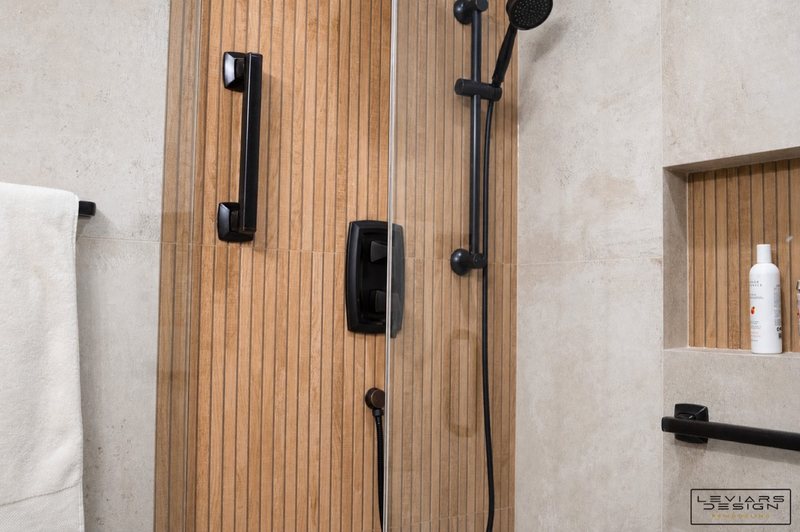 Warm modern bathroom with wood-look tile and black fixtures, view 6 of 8