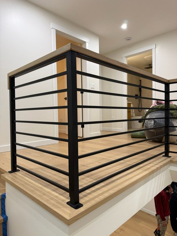 Custom black metal stair railing and handrail installation detail, view 2 of 18