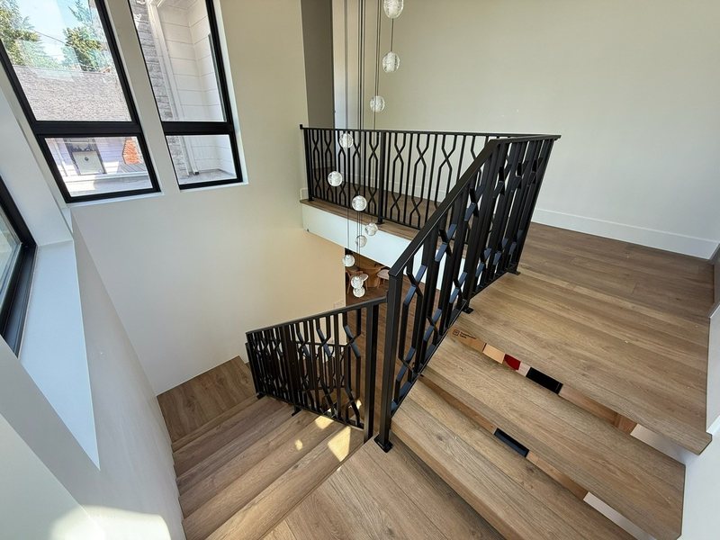 Custom black metal stair railing and handrail installation detail, view 6 of 18