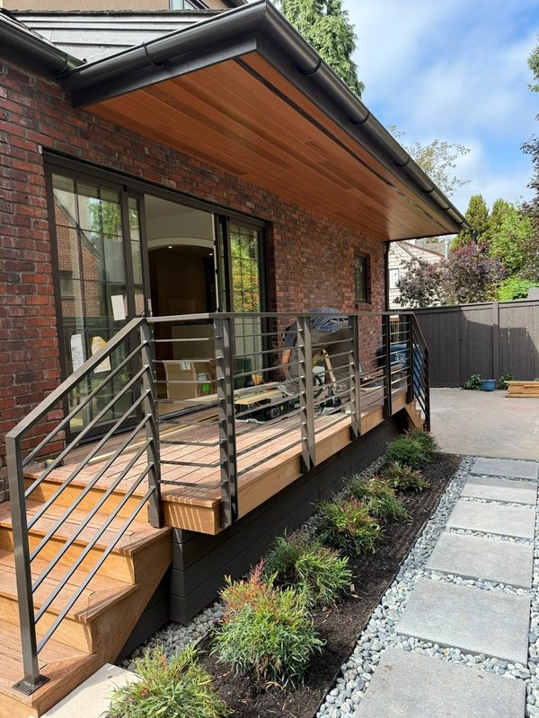 Custom black metal stair railing and handrail installation detail, view 7 of 18