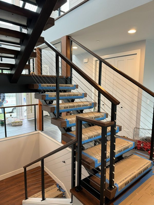 Custom black metal stair railing and handrail installation detail, view 9 of 18