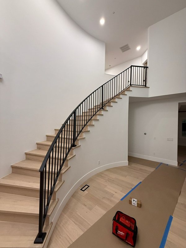 Custom black metal stair railing and handrail installation detail, view 11 of 18