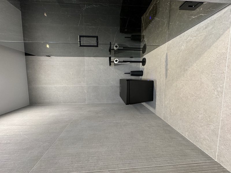 Modern remodeled bathroom with coordinated tile, lighting and storage, view 4 of 9