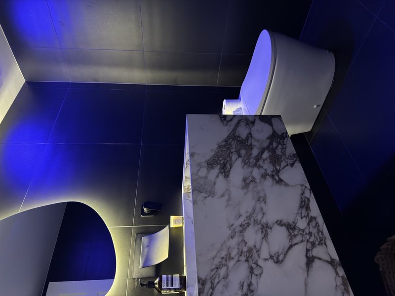 Modern remodeled bathroom with coordinated tile, lighting and storage, view 7 of 9