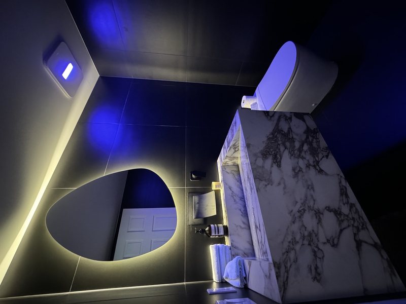 Modern remodeled bathroom with coordinated tile, lighting and storage, view 8 of 9