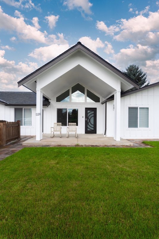 Exterior of the remodeled home with gabled roof and large windows