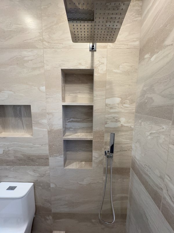 Shower fixtures and recessed tiled niches