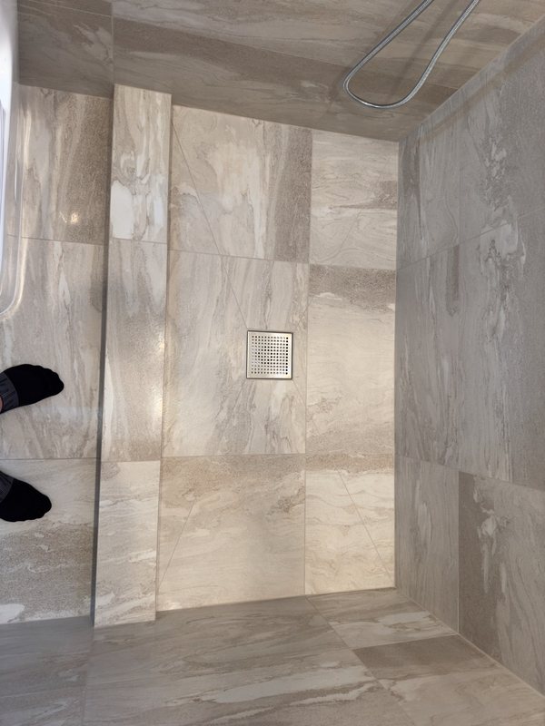 Stone-look tiled shower with glass enclosure