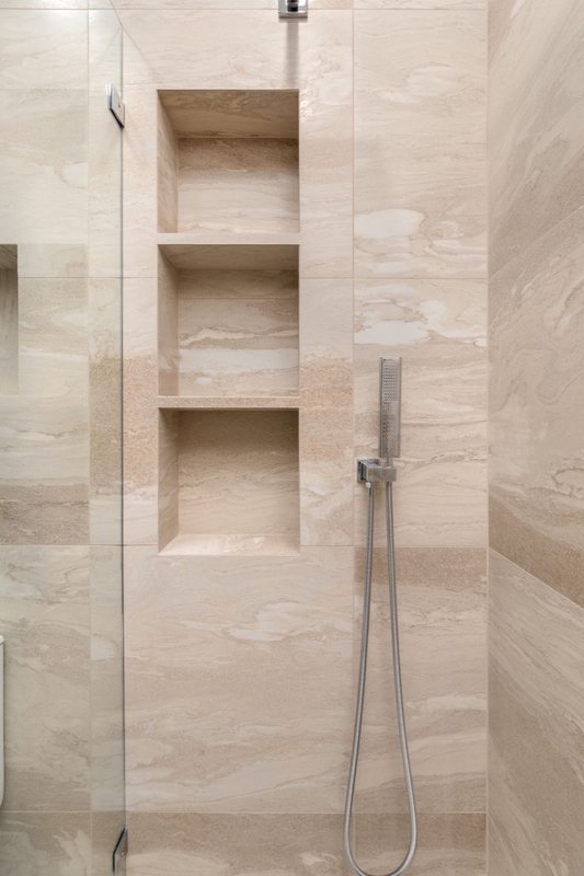 Stacked shower niches and handheld shower fixture