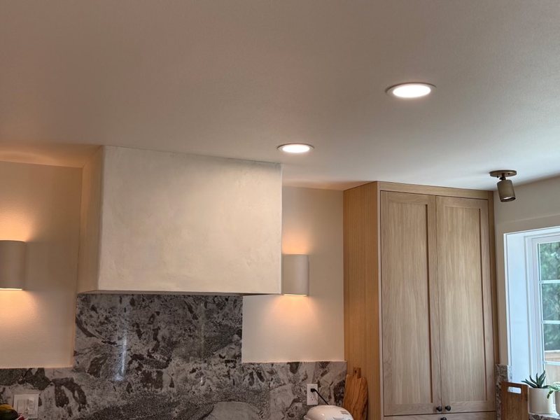 Custom sculpted plaster range hood above a remodeled kitchen range, view 2 of 6