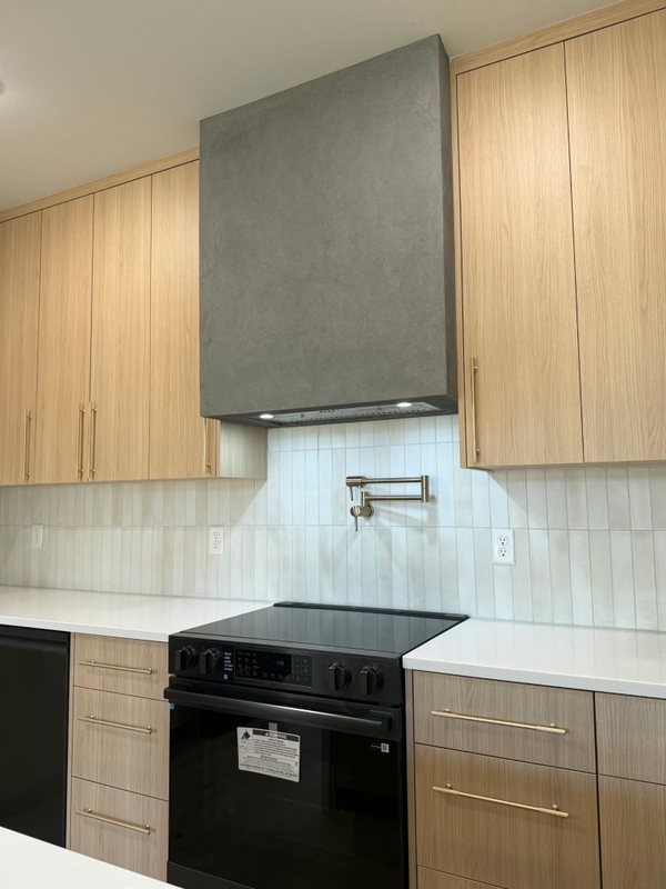 Custom sculpted plaster range hood above a remodeled kitchen range, view 4 of 6