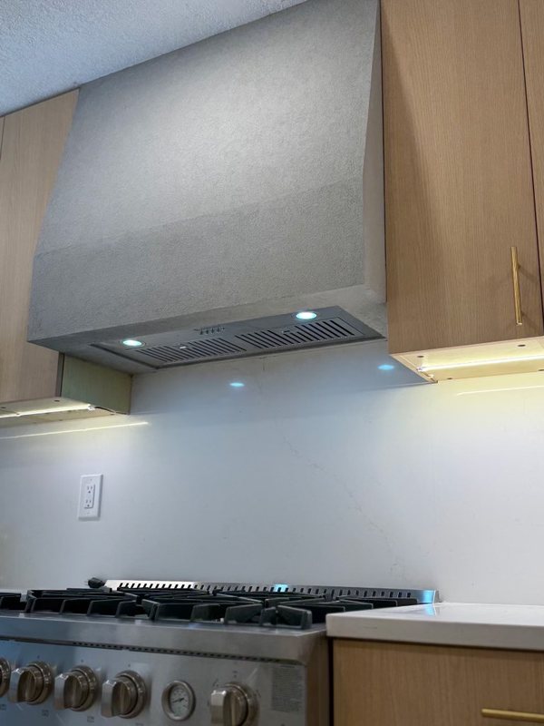 Custom sculpted plaster range hood above a remodeled kitchen range, view 5 of 6