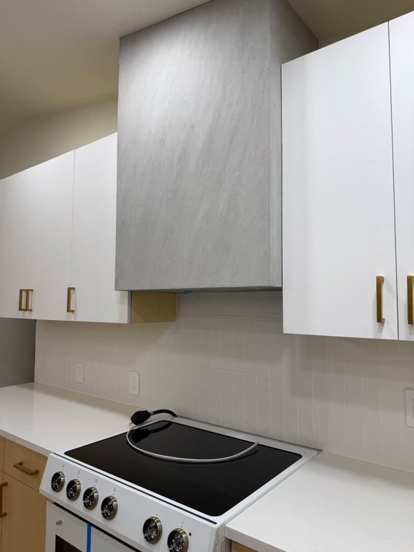 Custom sculpted plaster range hood above a remodeled kitchen range, view 6 of 6