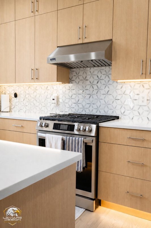 Natural-wood kitchen with white island countertop, pendant lights and coordinated cabinetry, view 7 of 20