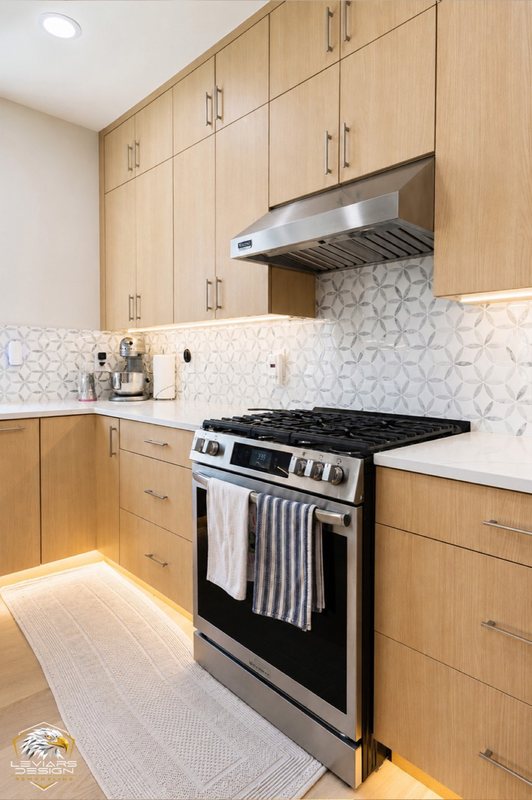 Natural-wood kitchen with white island countertop, pendant lights and coordinated cabinetry, view 8 of 20