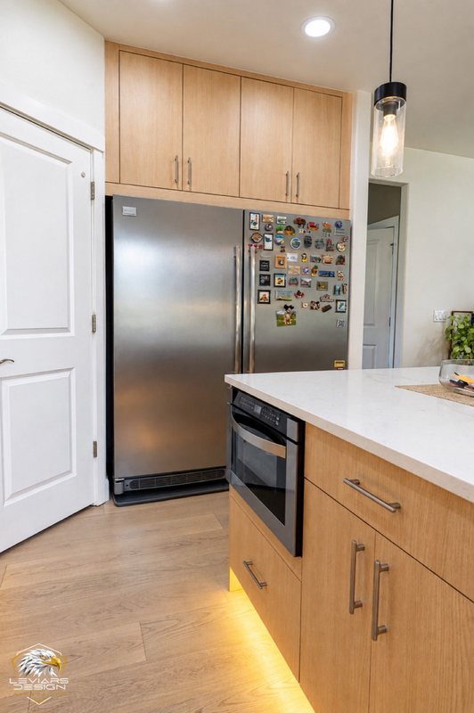 Natural-wood kitchen with white island countertop, pendant lights and coordinated cabinetry, view 9 of 20