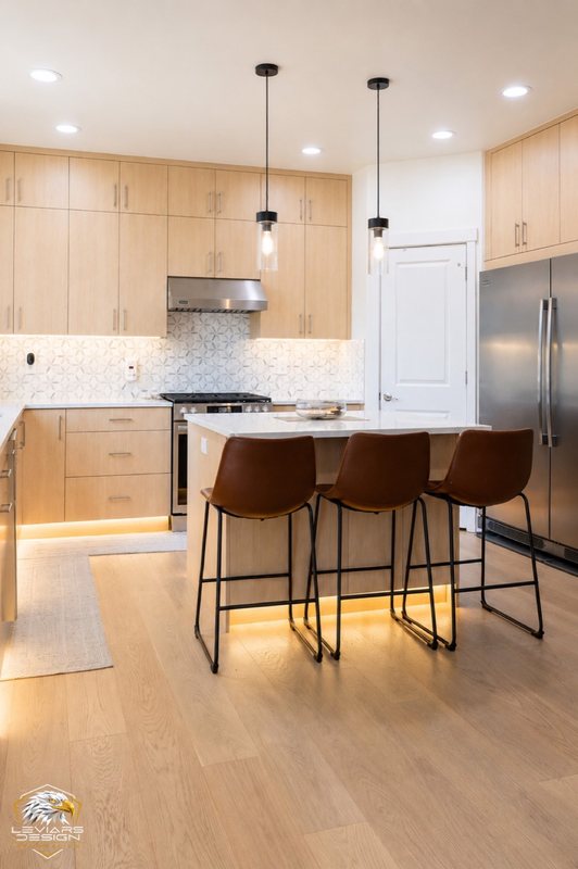 Natural-wood kitchen with white island countertop, pendant lights and coordinated cabinetry, view 11 of 20