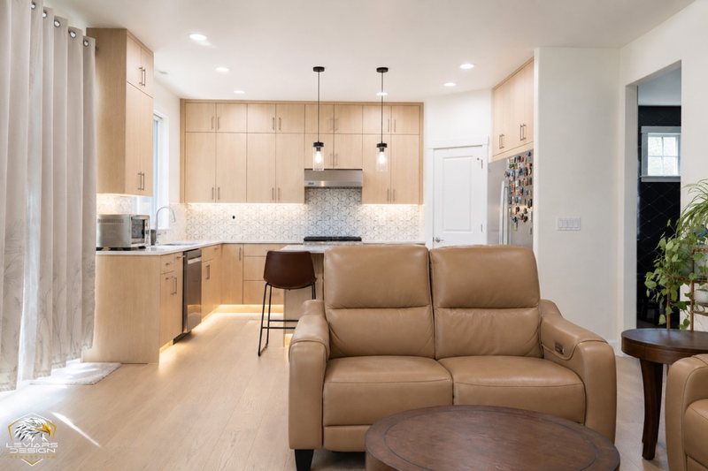 Natural-wood kitchen with white island countertop, pendant lights and coordinated cabinetry, view 12 of 20