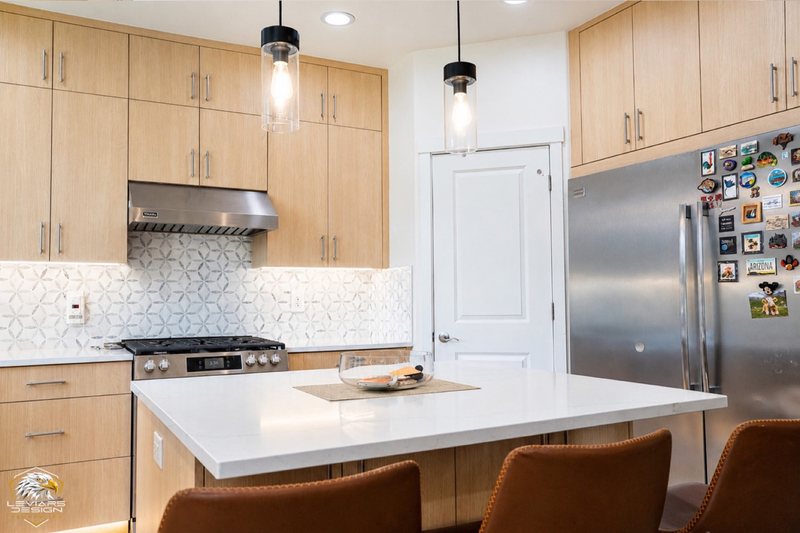 Natural-wood kitchen with white island countertop, pendant lights and coordinated cabinetry, view 20 of 20