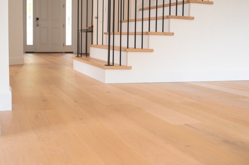 Connected dining room, staircase, fireplace and light oak flooring