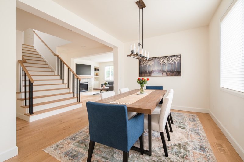 Connected whole-home interior with dining room, stairs, fireplace and flooring, view 8 of 12