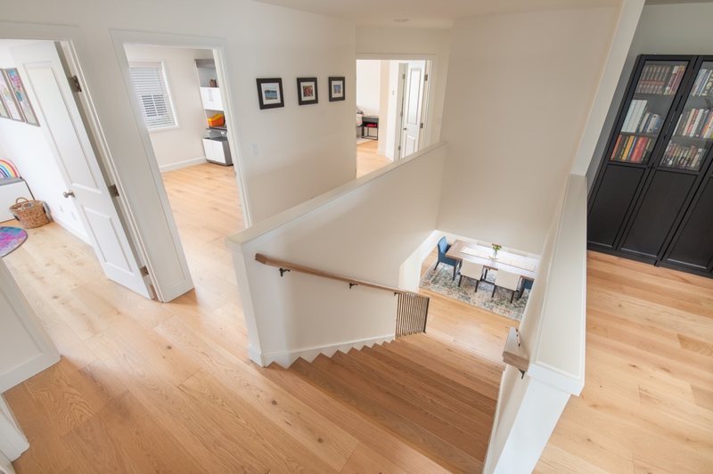 Connected whole-home interior with dining room, stairs, fireplace and flooring, view 9 of 12