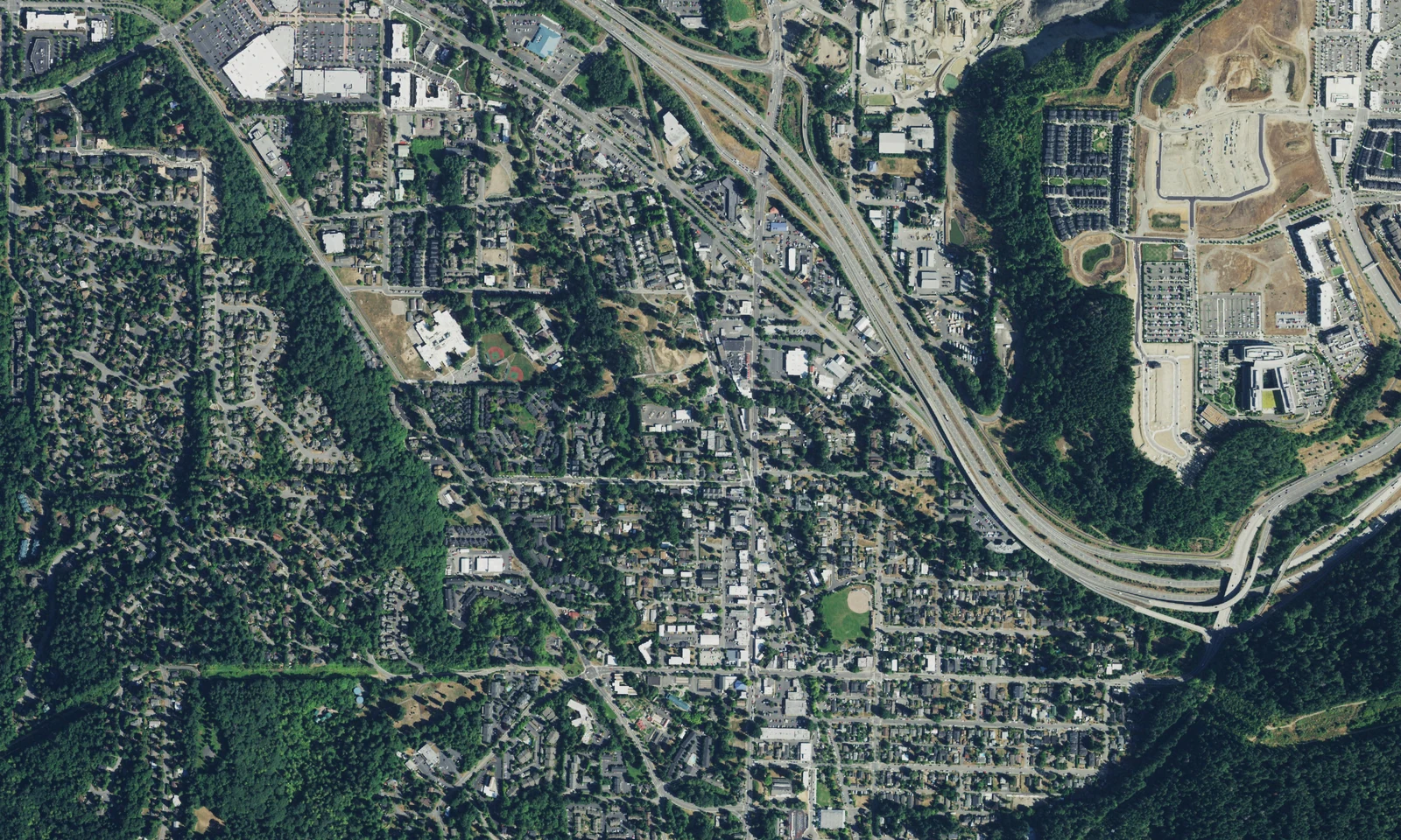 An aerial view of central Issaquah, Washington, with its street grid, tree cover and I-90 corridor. LeviArs Design & Remodeling service area.