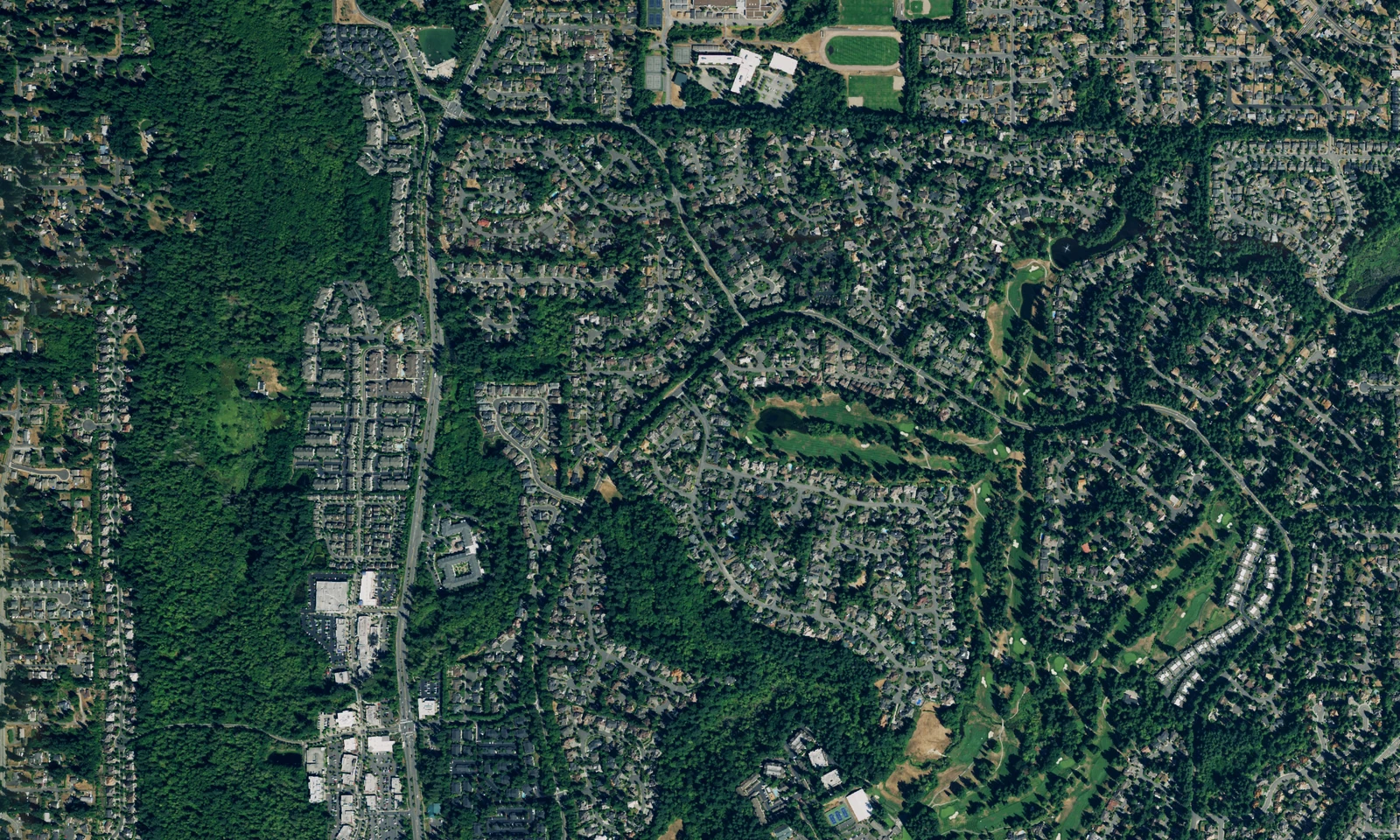 Mill Creek, Washington, from above, with curving neighborhoods, green fairways and wooded open spaces. LeviArs Design & Remodeling service area.