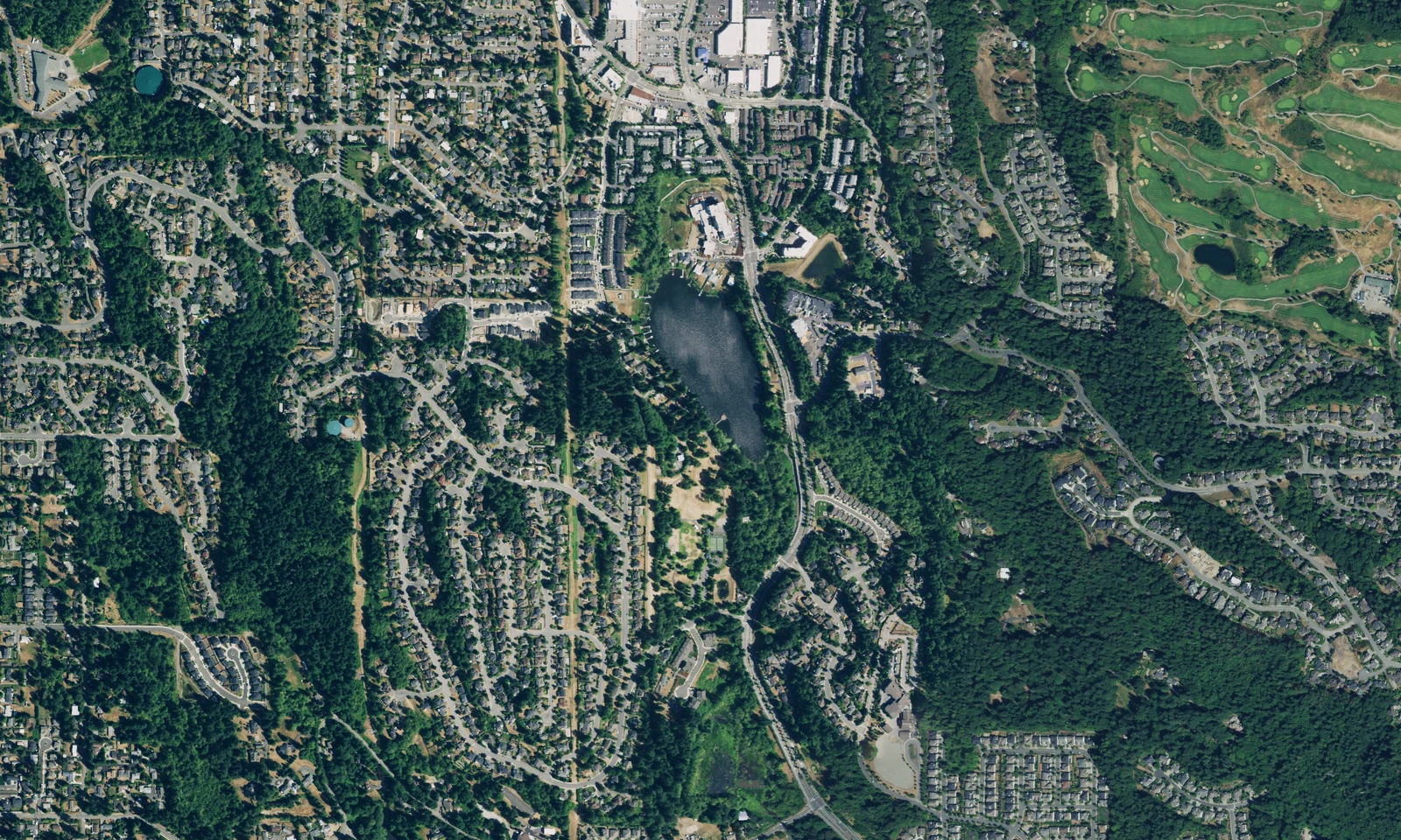 Newcastle, Washington, from above, showing hillside neighborhoods, wooded corridors and green fairways. LeviArs Design & Remodeling service area.