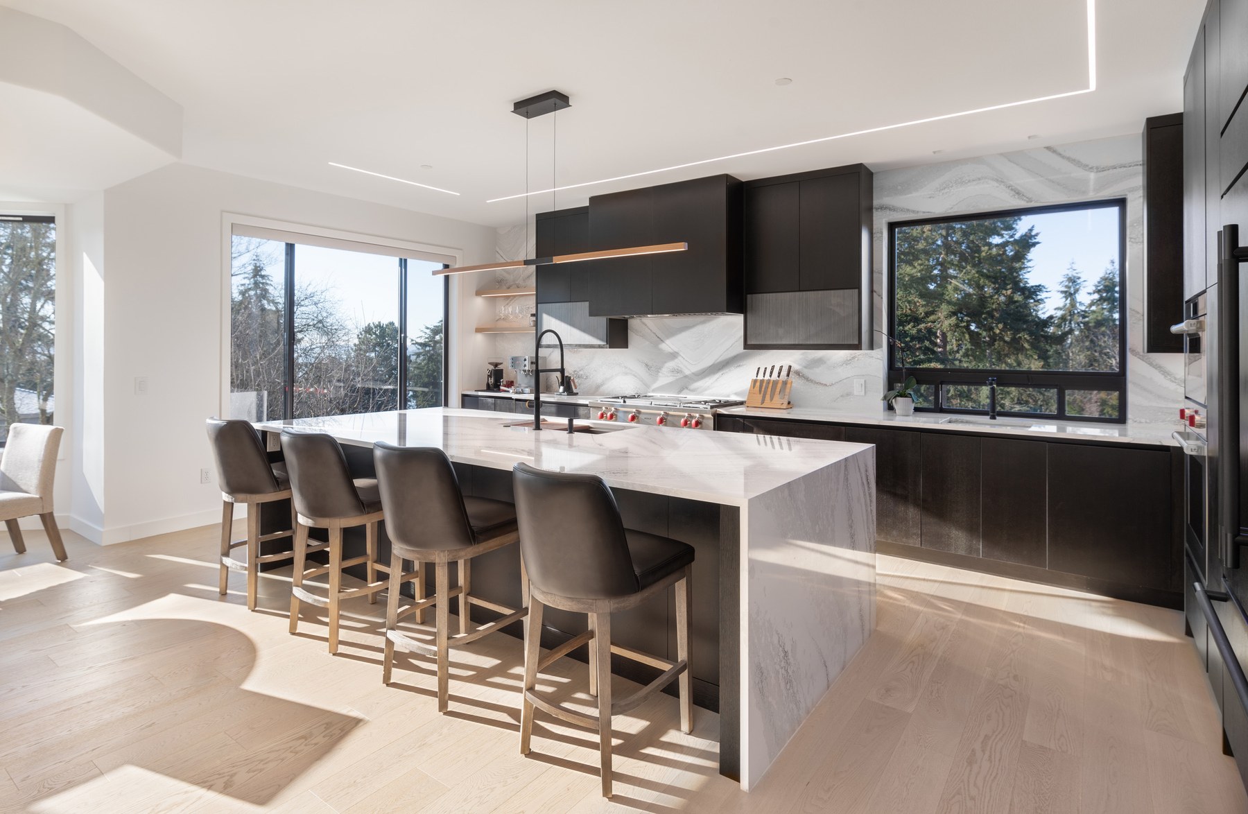 Same Klee kitchen after remodeling, with a rectangular island, seating and coordinated tall storage