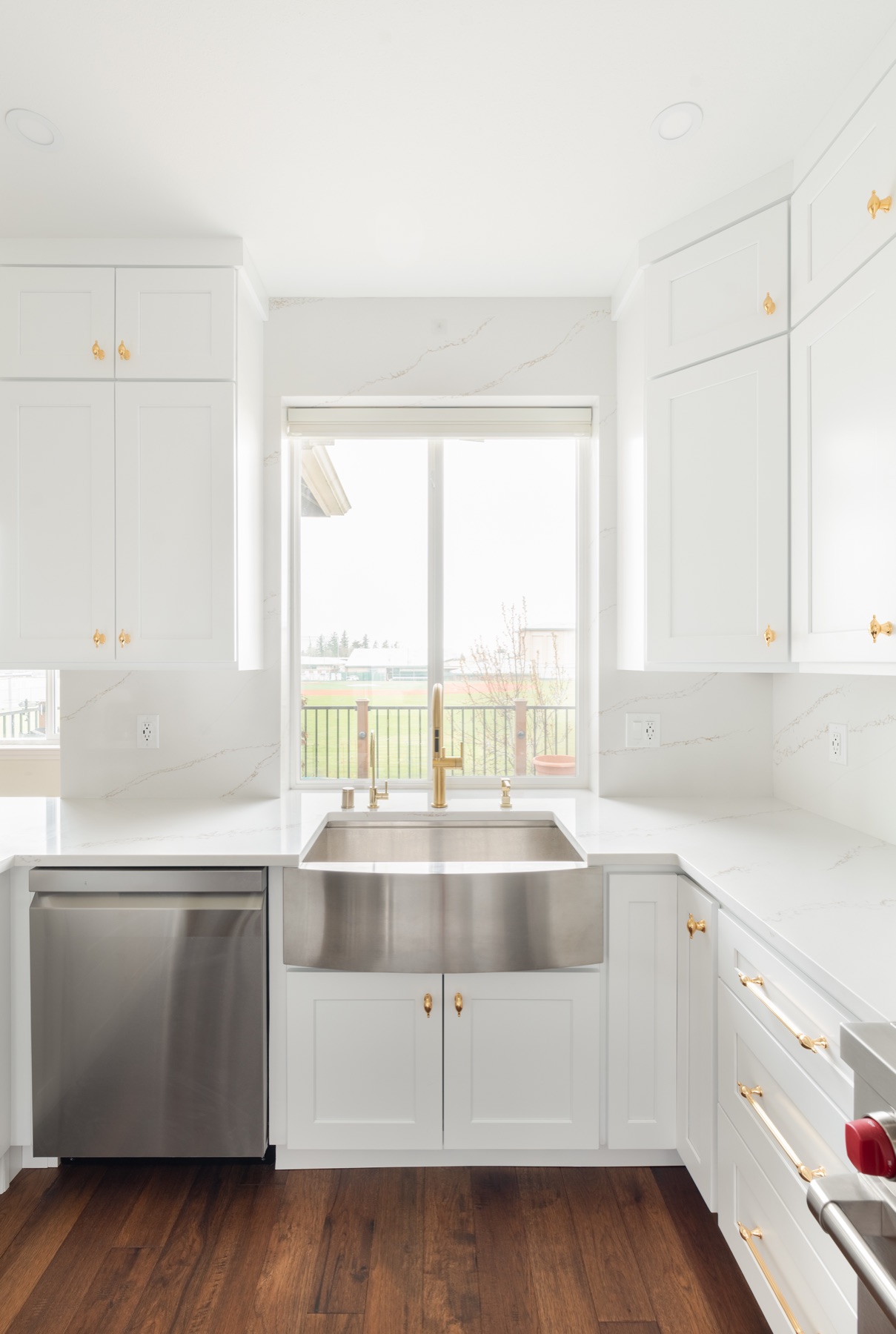 White oak kitchen sink wall with brass fixtures