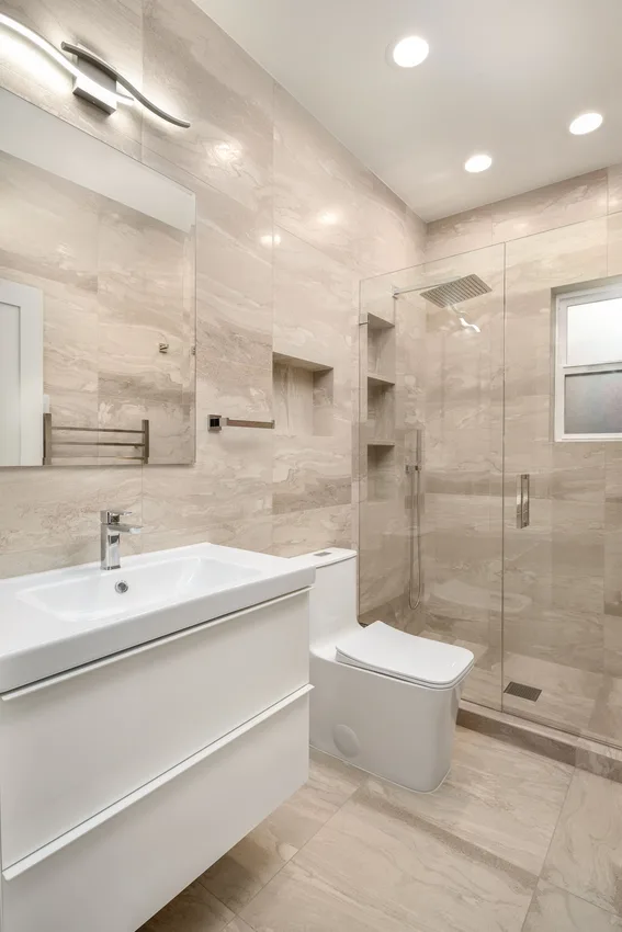 White vanity and mirrored cabinet beside the tiled shower in Bothell, Washington