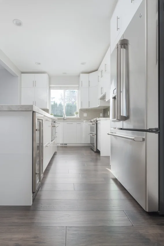 White kitchen cabinetry above gray-brown flooring in Lynnwood, Washington